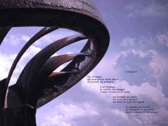 Roue du barrage de Chancy-Pougny exposée à Challex, dans l'Ain, avec en arrière plan les nuages sur le Jura. Poème sur l'alliance possible entre les hommes et la nature.